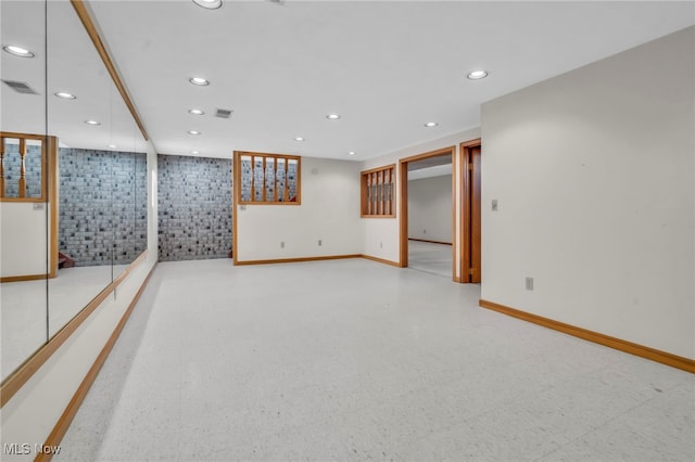 finished basement with tile patterned floors, visible vents, recessed lighting, and baseboards