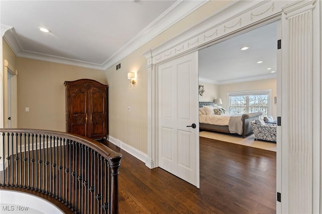 hallway with dark wood-type flooring, recessed lighting, crown molding, and baseboards