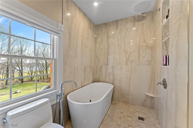 bathroom featuring a soaking tub, a healthy amount of sunlight, toilet, and a shower