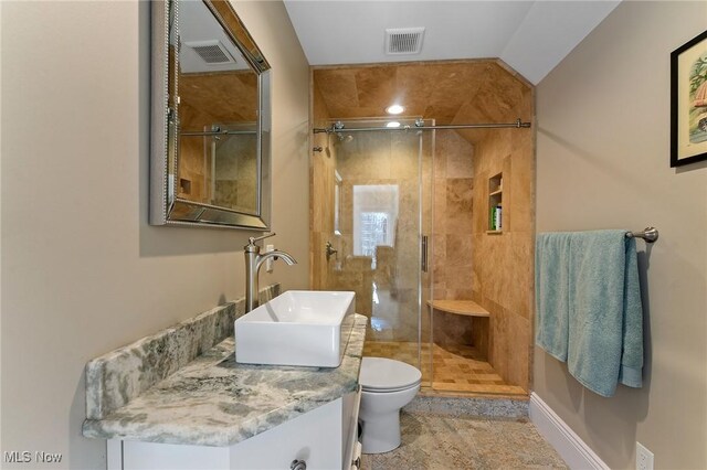 bathroom featuring vanity, toilet, visible vents, and a stall shower