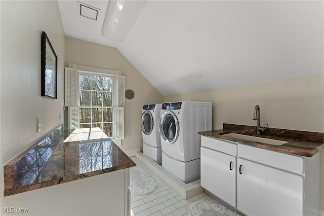 clothes washing area featuring visible vents, cabinet space, light tile patterned flooring, washer and dryer, and a sink