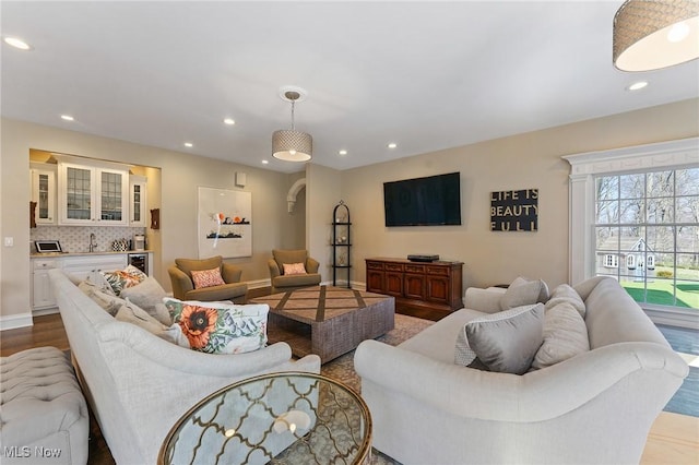 living area with recessed lighting, baseboards, wine cooler, and wood finished floors