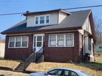 bungalow-style house with entry steps and brick siding