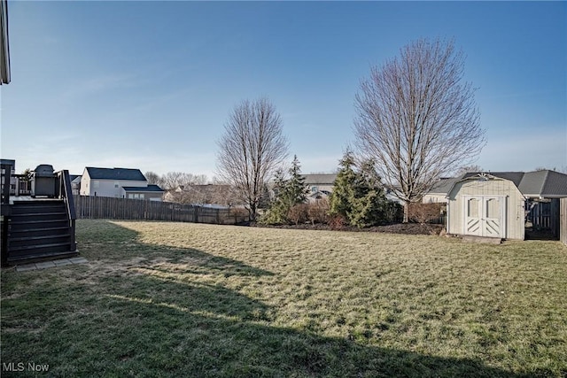 view of yard featuring a storage unit, an outdoor structure, and fence