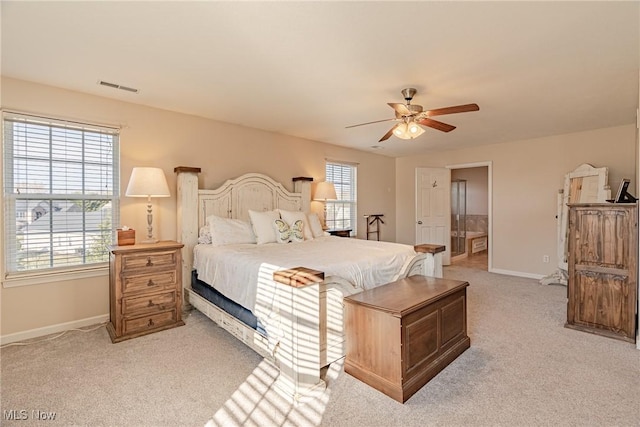 bedroom featuring baseboards, visible vents, multiple windows, and light carpet