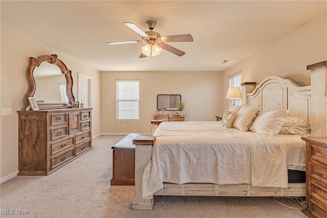 bedroom with ceiling fan, baseboards, and light carpet