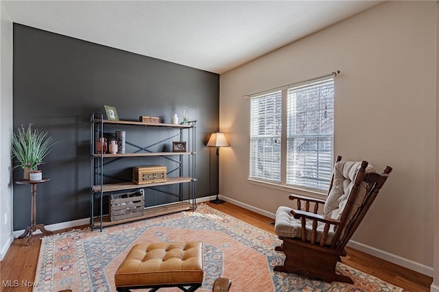 living area with baseboards and wood finished floors