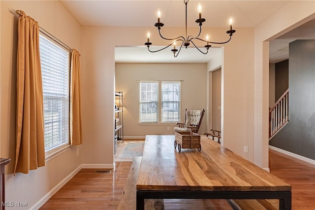 sitting room featuring visible vents, baseboards, stairway, wood finished floors, and a notable chandelier