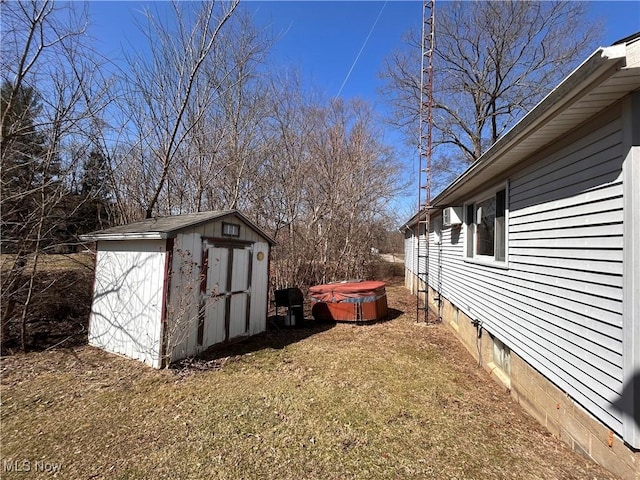 view of yard with an outdoor structure, a storage unit, and a hot tub