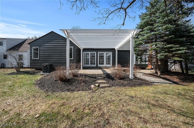 back of property with a patio area, central AC unit, a lawn, and french doors