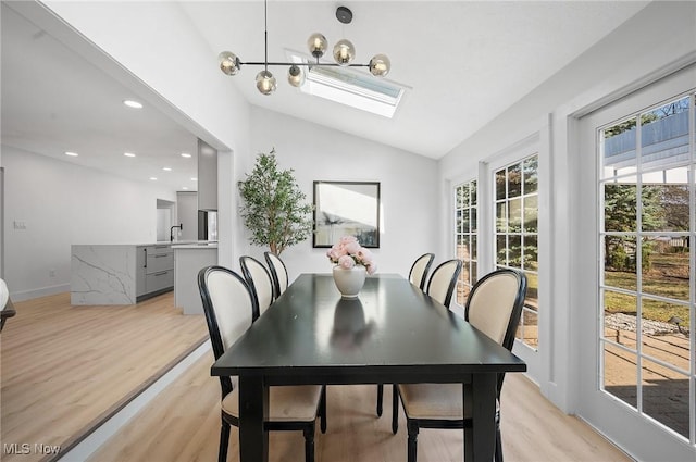 dining room featuring recessed lighting, baseboards, lofted ceiling, and light wood-style floors