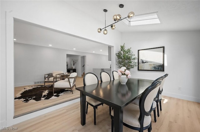 dining space featuring baseboards, visible vents, light wood finished floors, recessed lighting, and vaulted ceiling