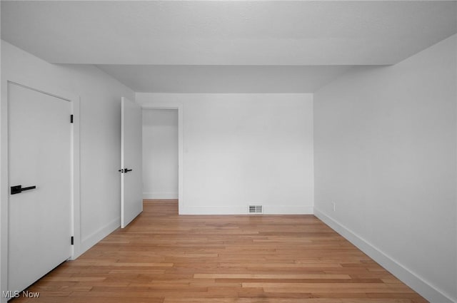 unfurnished bedroom with light wood-style floors, visible vents, and baseboards