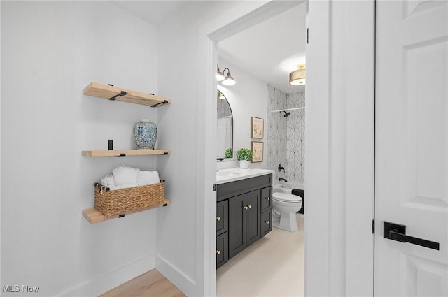 full bathroom with baseboards, toilet, shower / bath combo, and vanity