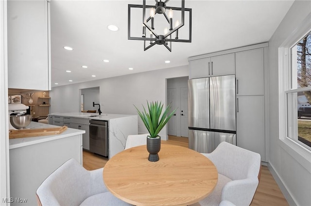 dining room featuring a notable chandelier, recessed lighting, light wood-style floors, and a wealth of natural light