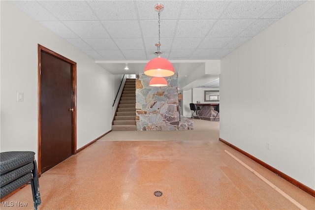 interior space with a paneled ceiling, stairs, and baseboards