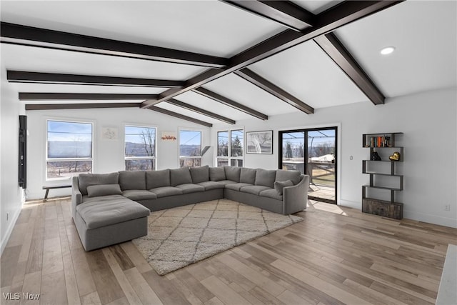 living room with lofted ceiling with beams, light wood-type flooring, and baseboards