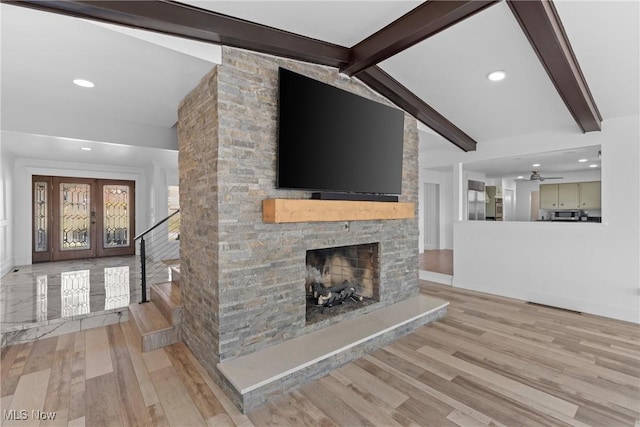 unfurnished living room with lofted ceiling with beams, wood finished floors, recessed lighting, stairway, and a fireplace