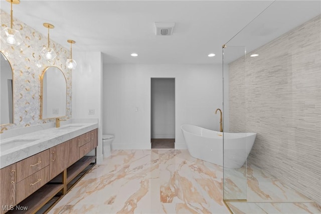 full bath featuring a sink, a soaking tub, marble finish floor, and double vanity