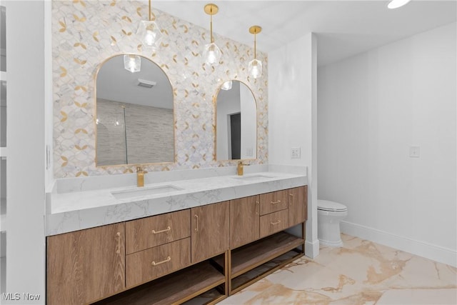 bathroom with double vanity, toilet, marble finish floor, and a sink