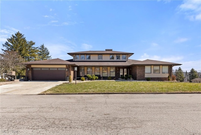 prairie-style home featuring brick siding, a front lawn, concrete driveway, and an attached garage