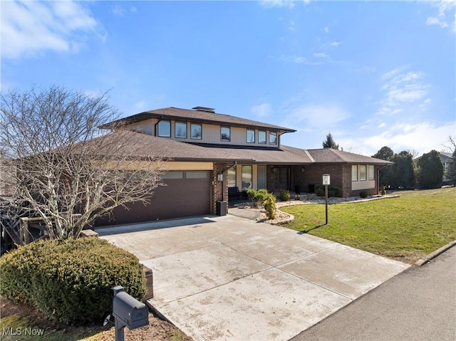 prairie-style home featuring a garage, a front lawn, concrete driveway, and brick siding