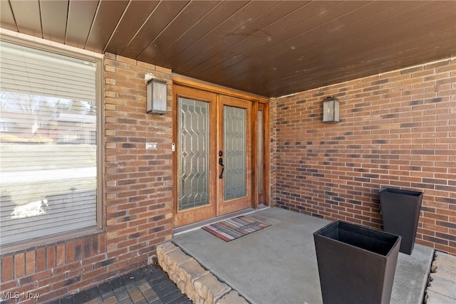 view of exterior entry with brick siding and french doors