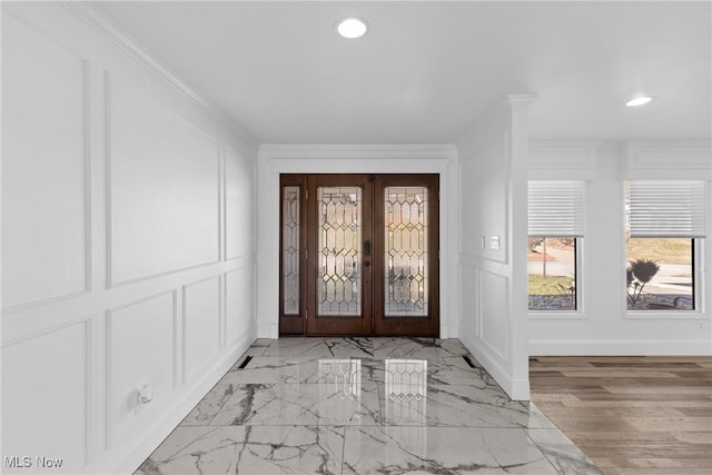 entrance foyer with marble finish floor, recessed lighting, french doors, crown molding, and a decorative wall