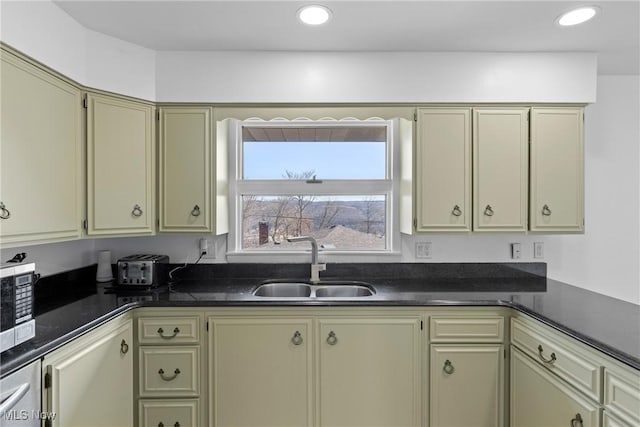 kitchen featuring a sink, stainless steel microwave, dark countertops, and recessed lighting