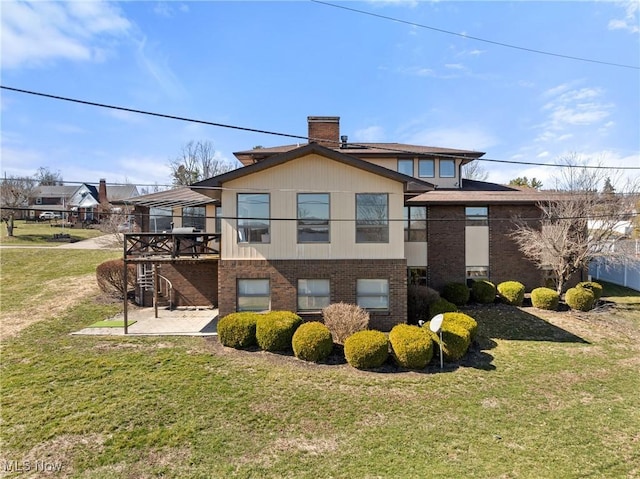 view of home's exterior with brick siding, stairway, a chimney, a yard, and a deck