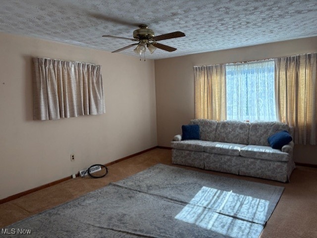 unfurnished living room with baseboards, a textured ceiling, and a ceiling fan