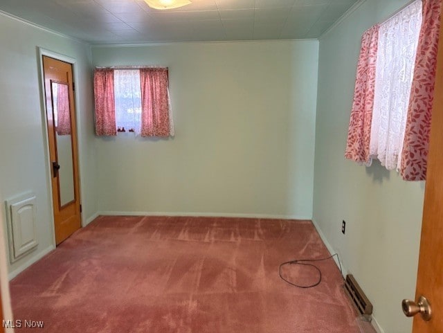 carpeted spare room featuring visible vents, baseboards, and ornamental molding