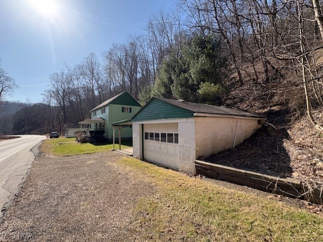 exterior space featuring an outbuilding, a lawn, a garage, and driveway