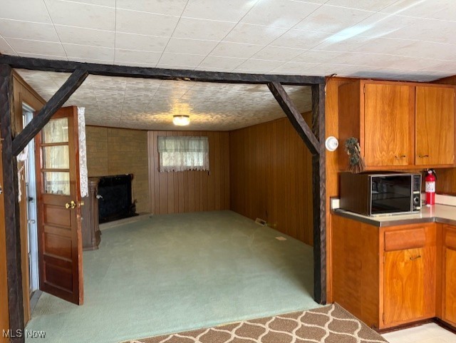 basement with light carpet and wood walls