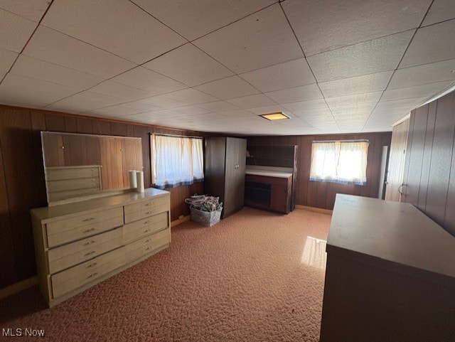 unfurnished bedroom featuring light carpet and wood walls