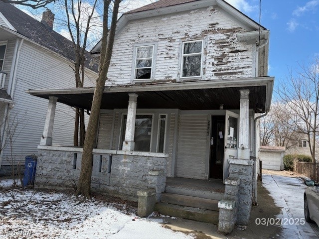 view of front facade featuring a detached garage and covered porch