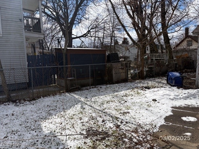 yard covered in snow featuring fence