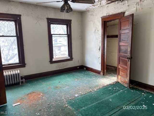 unfurnished bedroom with radiator and baseboards