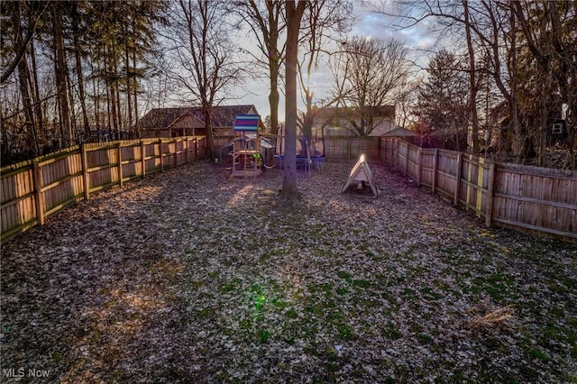 view of yard with a playground and a fenced backyard