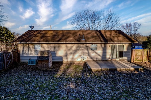 rear view of house with central AC unit, a patio area, and fence