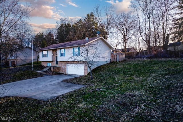 exterior space with a garage, a lawn, concrete driveway, and fence