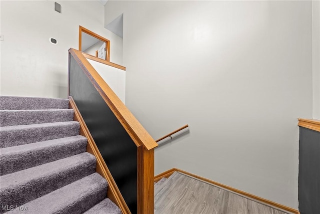 stairway with baseboards and wood finished floors