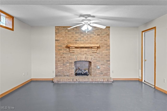 unfurnished living room featuring finished concrete floors, a fireplace, a textured ceiling, and baseboards