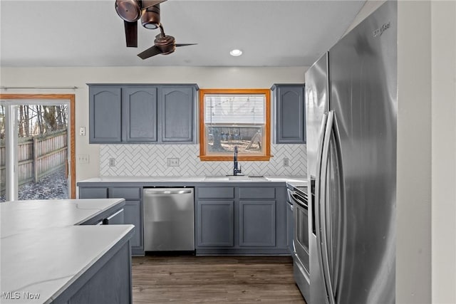 kitchen with a sink, light countertops, dark wood finished floors, and stainless steel appliances