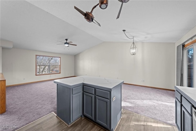 kitchen featuring dark colored carpet, gray cabinetry, open floor plan, and vaulted ceiling