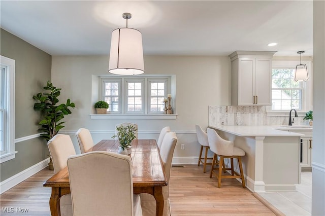 dining room featuring recessed lighting, baseboards, and light wood-style floors