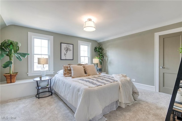 bedroom featuring light colored carpet and lofted ceiling