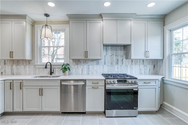 kitchen featuring a sink, decorative backsplash, light countertops, and stainless steel appliances