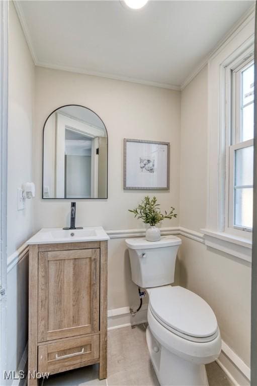 bathroom featuring crown molding, toilet, vanity, and baseboards