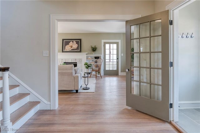 interior space featuring light wood-type flooring, baseboards, and stairs